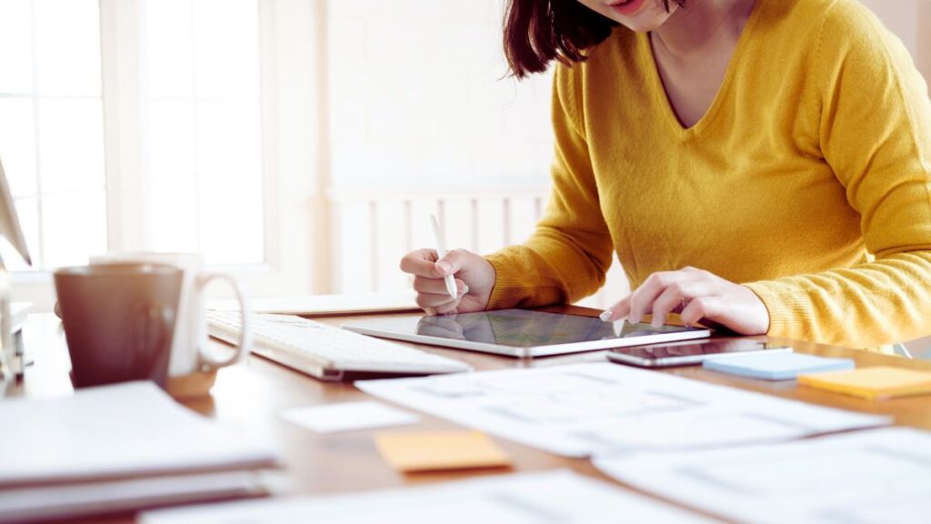 A woman drawing a design on a tablet