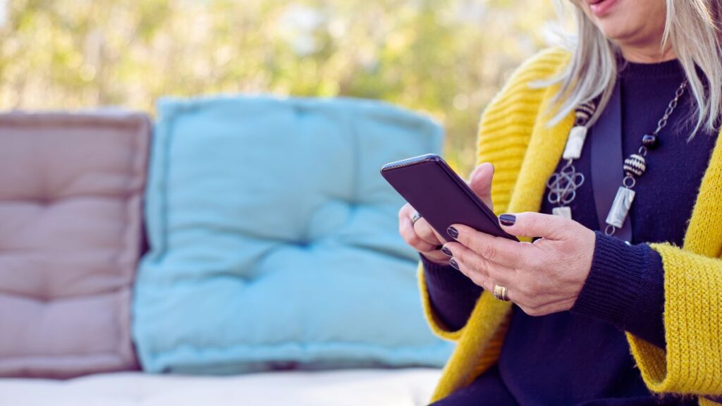 A woman sitting, swiping on a smartphone