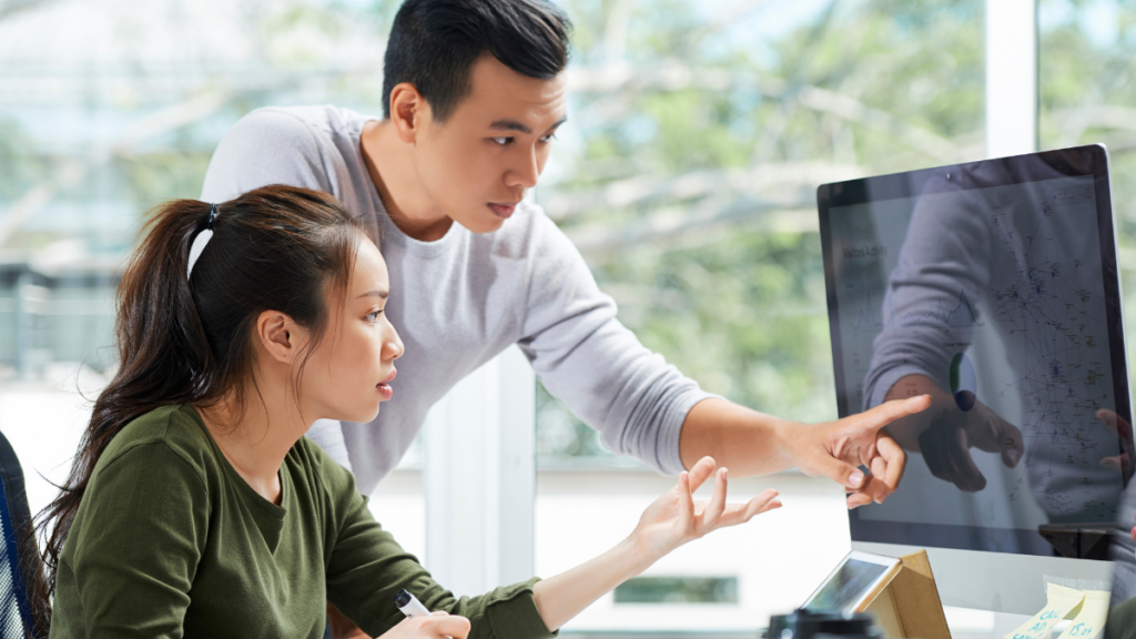 Two people discussing building trust through personalized benefits while pointing at the computer screen