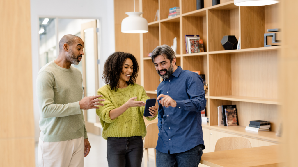 Team of 3 satisfied users pointing at the smartphone